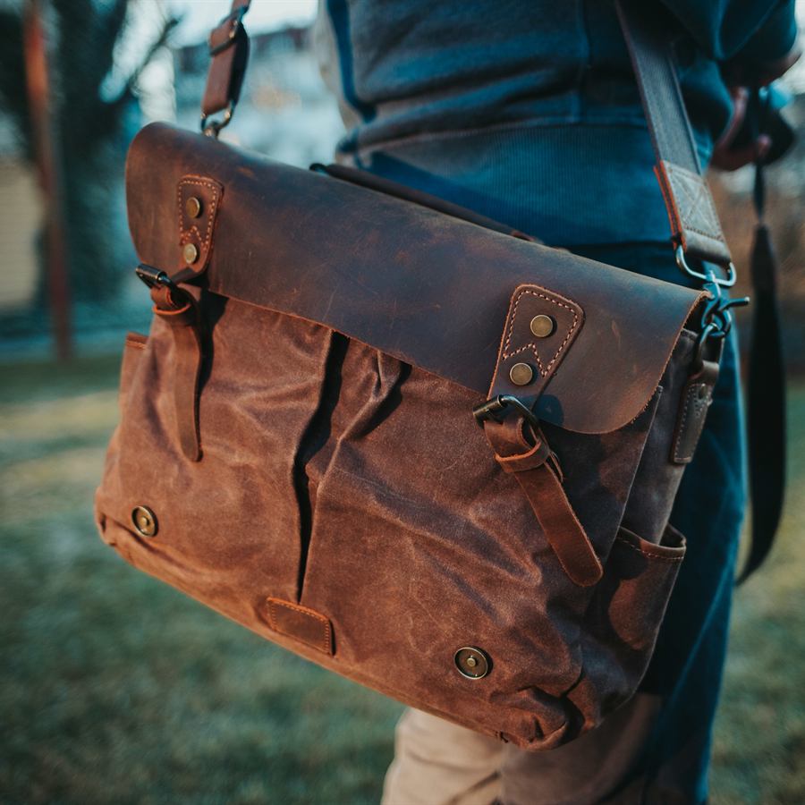 Brown leather and canvas messenger bag worn on the shoulder
