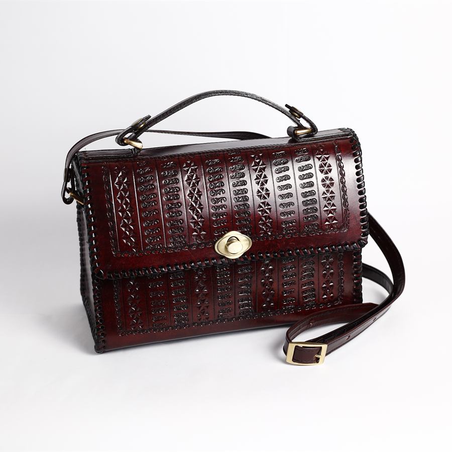 Oxblood embossed leather satchel with a turn-lock, top handle and shoulder strap